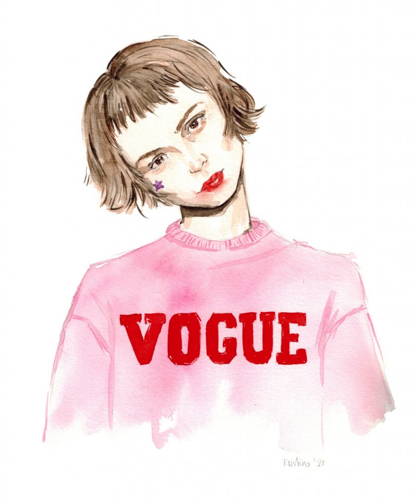 Frau mit kurzem Bob in einem rosa Sweat-Shirt mit roter Vogue Aufschrift in Blockbuschstaben lehnt den Kopf zu Seite