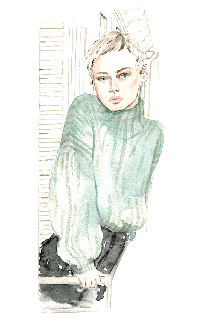 kurzhaarige Frau steht auf einem Balkon in Paris und trägt einen mintgrünen Wollpulli und schwarzen Rock von Isabell Marant