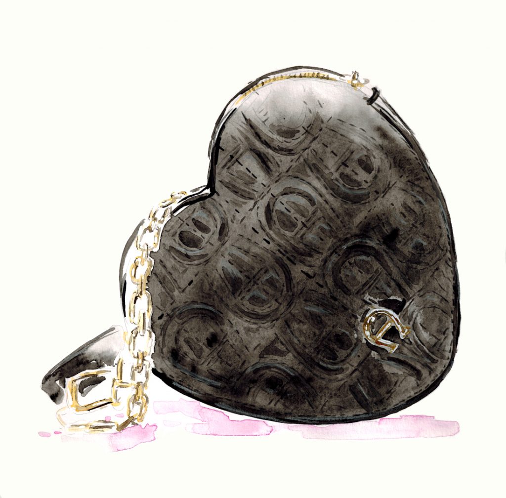 Schwarze Aigner Tasche in Herzform mit goldener Kette als Träger.