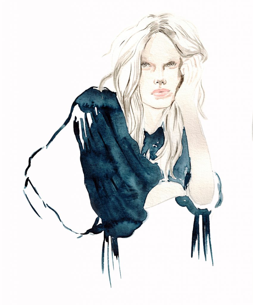 Eine Frau hat ihren Kopf auf die Hand gelehnt und trägt eine blaue Bluse von Isabel Marant. 